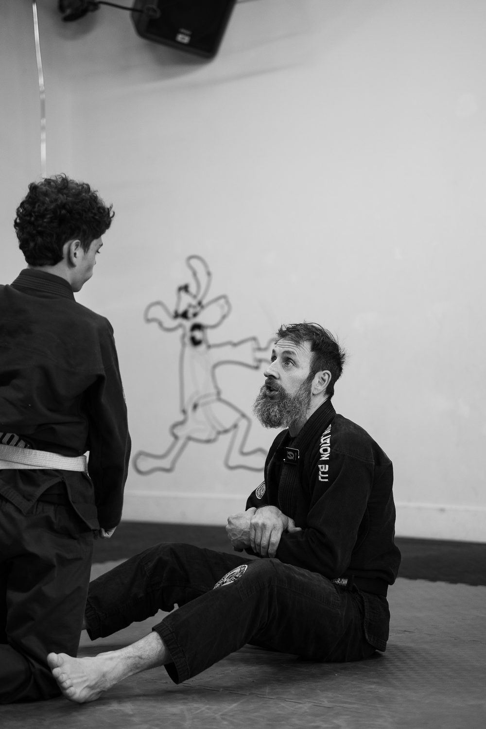 José Vinciarelli assis sur le tatami, en discussion avec un élève