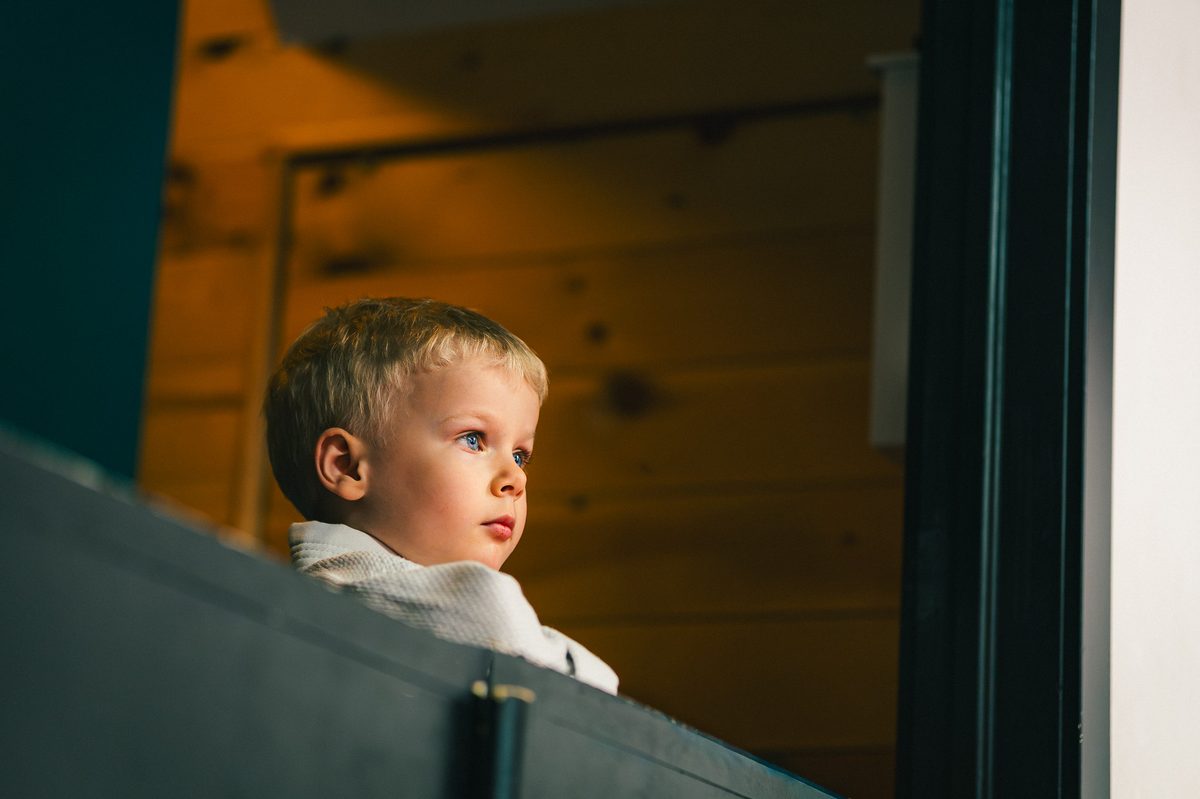 Un jeune enfant observe le cours depuis l'entrée du tatami