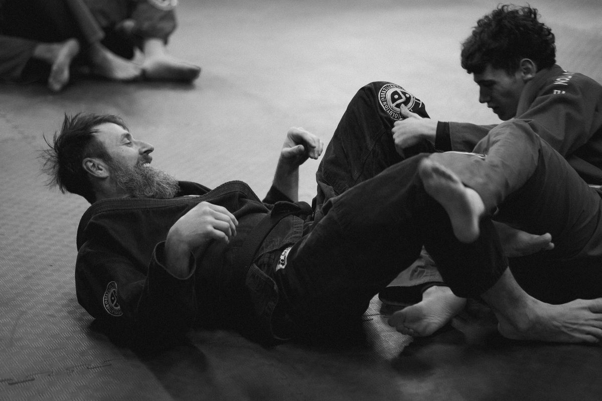 Deux adultes en jujitsugi noir pendant un cours de jiu-jitsu brésilien